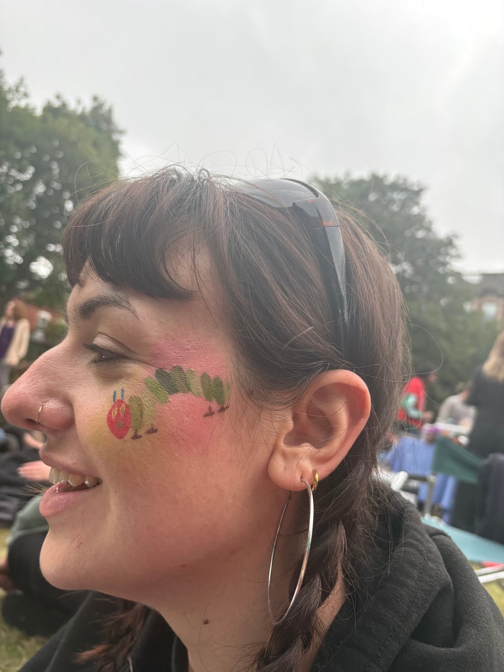 A colourful caterpillar cheek design painted by Ellie